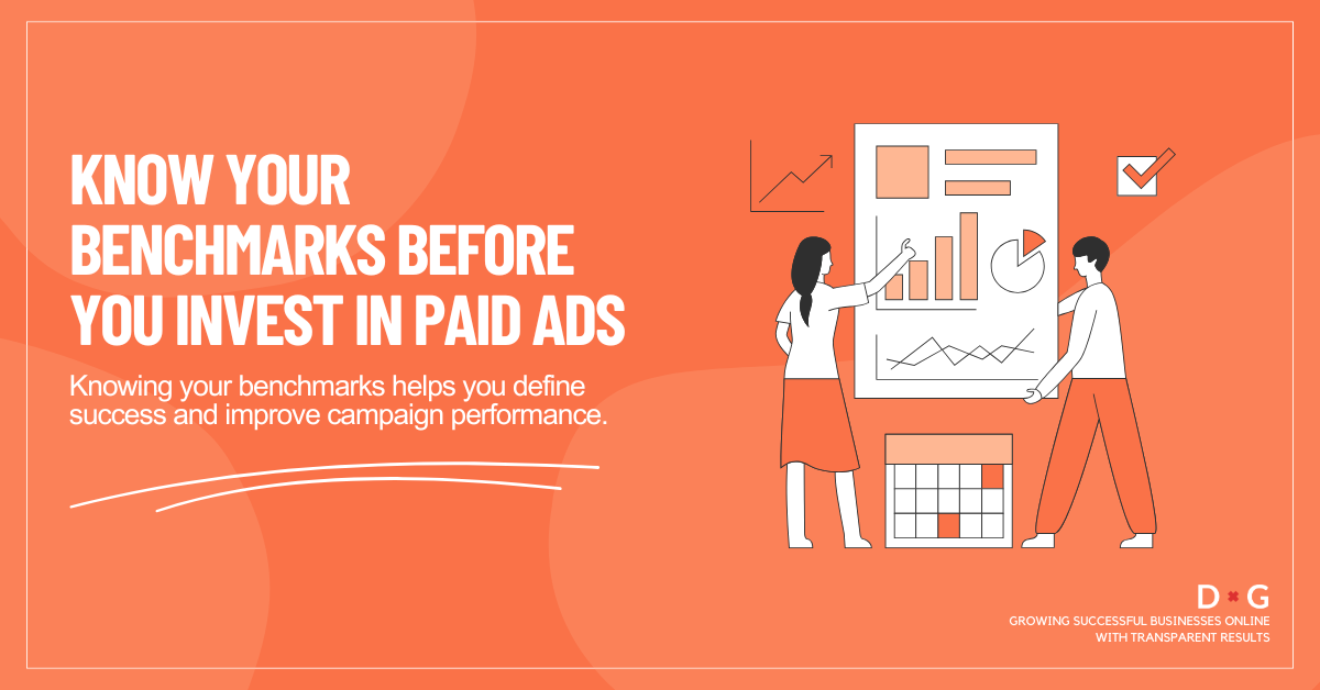 Two marketers reviewing charts and data on a large presentation board, illustrating the importance of knowing benchmarks before running paid ads.